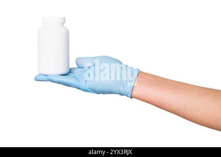 Main dans des gants médicaux tenant un pot blanc avec des comprimés ou des capsules sur un fond vide. Stockage de médicaments, emballage pharmaceutique, soins de santé. Banque D'Images