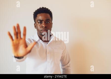 Portrait de jeune homme d'affaires qui est sérieux et s'arrête avec la main. Banque D'Images