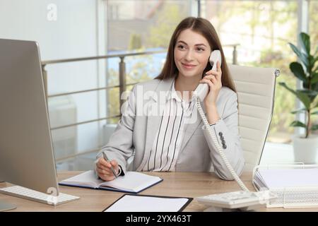 Banquier parlant au téléphone à table dans le bureau Banque D'Images