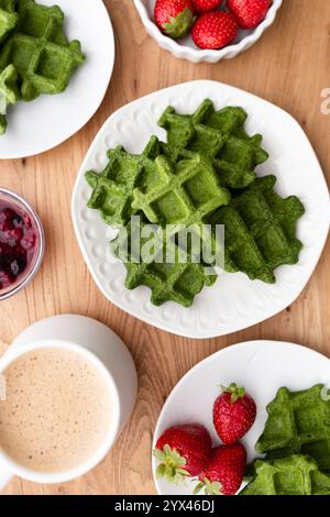 Une scène de petit déjeuner dynamique et nutritive avec gaufres vertes servies avec des fraises fraîches et une tasse de café, parfait pour un délicieux et sain Banque D'Images