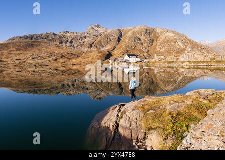 Femme debout près du lac Totesee sur le col Grimsel en Suisse. Réflexion tôt le matin dans l'eau cristalline. Banque D'Images