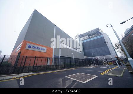 Une vue extérieure de Telehouse Europe, un centre de données à la pointe de la technologie situé à Telehouse South à Londres. Le complexe intègre une clôture de 3 m de haut classée PAS68, qui est résistante aux chocs pour empêcher tout véhicule d'être utilisé comme bélier pour entrer dans le bâtiment ; un portail de sécurité qui apporte une interface humaine au périmètre des locaux et améliore le filtrage de sécurité avant d'entrer dans les locaux, et entrée et sortie piétons et serrures de véhicule pour empêcher les chutes. Date de la photo : jeudi 12 décembre 2024. Banque D'Images