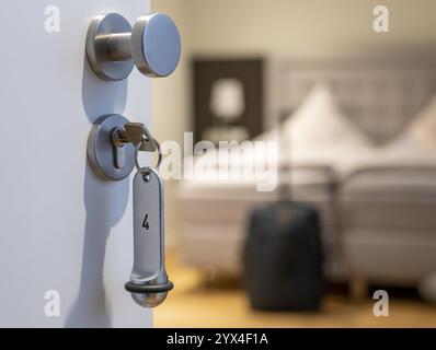 Image symbolique d'un hôtel, clé insérée dans la porte d'une chambre d'hôtel, serrure analogique Banque D'Images