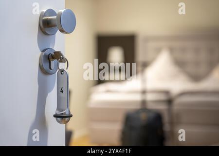 Image symbolique d'un hôtel, clé insérée dans la porte d'une chambre d'hôtel, serrure analogique Banque D'Images