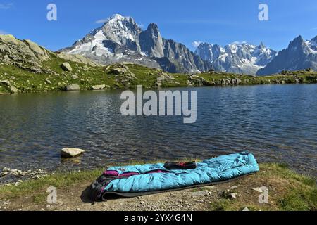 Site de bivouac au bord du lac de montagne des Lacs des Cheserys dans la réserve naturelle des aiguilles rouges, avec l'aiguille verte et l'aiguille du Dru Banque D'Images