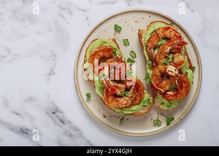 Sandwichs à l'avocat et aux crevettes caramélisées, micro-légumes verts, petit déjeuner, sur une assiette, vue de dessus, fait maison, pas de gens Banque D'Images