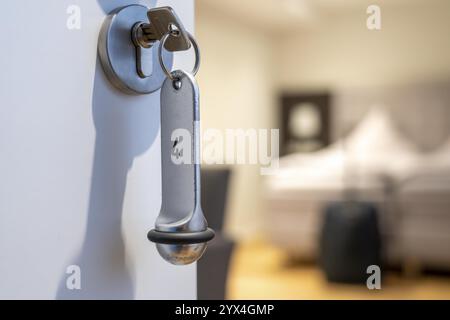 Image symbolique d'un hôtel, clé insérée dans la porte d'une chambre d'hôtel, serrure analogique Banque D'Images