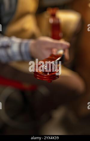 Gros plan d'un luthier examinant attentivement le rouleau d'un violon, mettant en valeur le savoir-faire artisanal et l'attention portée aux détails dans la fabrication du violon Banque D'Images