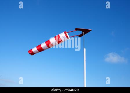 Chaussette à vent dans les couleurs rouge et blanche rayée avec flèche directionnelle, direction du vent, savoir d'où souffle le vent, aérodrome Banque D'Images