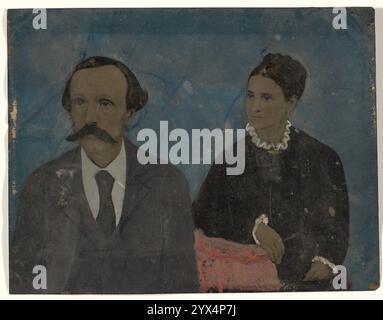 Portrait de couple, années 1860-1880s. Portrait d'un homme moustachu et d'une femme, les deux regardant vers la gauche. L'homme porte un costume sombre et une cravate et la femme porte une robe sombre avec un col et des poignets blancs volants. Banque D'Images