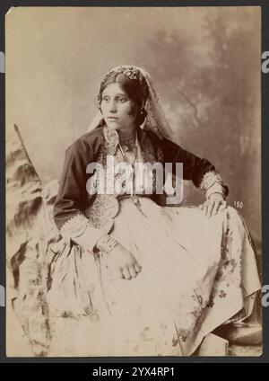 Portrait d'une femme, vers 1870. Informations supplémentaires : Portrait d'une femme assise reposant une main sur son genou. Elle porte une robe avec un motif floral. La femme a une veste avec un motif brodé et des ourlets. Elle porte un voile. Banque D'Images