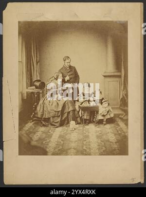 Portrait d'homme, de femme et d'enfants, vers 1859. Informations complémentaires : Portrait d'un homme, d'une femme et de deux enfants. L'homme est debout derrière la femme, qui est assise et a un plateau sur ses genoux. Un chapeau haut de gamme est sur une petite table sur piédestal derrière le couple. Les enfants sont debout derrière une table miniature. Un chien jouet est sur le sol devant le groupe. Banque D'Images