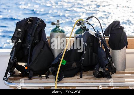 Concept de plongée sous-marine avec réservoir et équipement couché sur un bateau au-dessus de la mer bleue et du soleil Banque D'Images