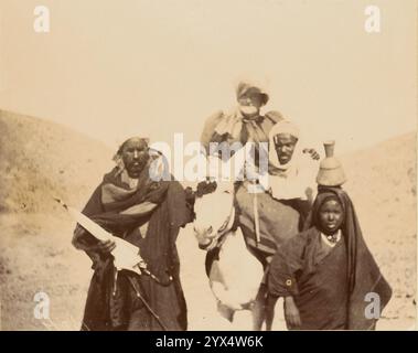 Hommes avec femme à dos de mule, vers 1860-1880. Informations supplémentaires : un portrait de groupe d'hommes rassemblés autour d'une femme chevauchant une mule blanche. L'homme qui se tient à côté de la tête de la mule tient un parapluie fermé. Un garçon en équilibre une urne sur sa tête est du côté opposé de la mule. Banque D'Images