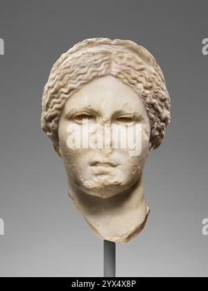 Tête de Vénus (type Knidian Aphrodite), 99-75 av. J.-C. Informations supplémentaires : cette tête féminine est légèrement au-dessus de la taille réelle. L'arrière de la tête est une surface plate en forme de coin avec des découpes pour la fixation de pièces sculptées séparément qui auraient complété l'anatomie de la tête. Les yeux sont en forme d'amande et creusés pour l'incrustation. Il y a quatre trous de perçage au bas des douilles pour la fixation d'œillets fabriqués séparément. Le cou est long et élancé avec deux indentations peu profondes à l'avant indiquant la chair. Les cheveux sont séparés au centre avec des brins ondulés brossés sur le Banque D'Images