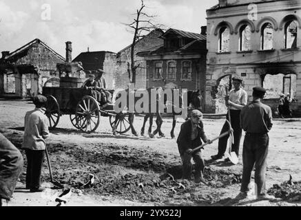 Russie 1942 Rzhev Russ. Civils travaillant sur la route devant les ruines à Rzhev. Section centrale du front de l'est dans la zone de la 110e division d'infanterie. [traduction automatique] Banque D'Images