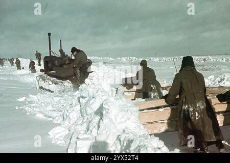 Les soldats de la 110e division d'infanterie travaillent au déneigement de la route près de leur poste à Makarowa, dans la section centrale du front de l'est, en hiver. Un tracteur tire des planches dans la neige. [traduction automatique] Banque D'Images