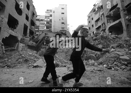 Beyrouth, Beyrouth, Liban. 13 décembre 2024. Des jeunes Libanais jouent devant l'épave d'un bâtiment détruit lors de raids aériens dans la région de Basta au fond de Beyrouth pendant les deux mois de guerre totale entre Israël et les militants du Hezbollah. Les habitants du quartier dévasté de Basta ont élevé la voix demandant au gouvernement de dédommager des dizaines de bâtiments dévastés et de trouver des abris pour les familles qui ont perdu leur maison. (Crédit image : © Marwan Naamani/ZUMA Press Wire) USAGE ÉDITORIAL SEULEMENT! Non destiné à UN USAGE commercial ! Banque D'Images