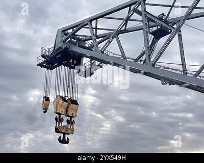 Grue industrielle avec crochets contre ciel nuageux Banque D'Images