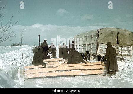 Les soldats de la 110e division d'infanterie travaillent au déneigement de la route près de leur poste à Makarowa, dans la section centrale du front de l'est, en hiver. Un tracteur tire des planches dans la neige. [traduction automatique] Banque D'Images