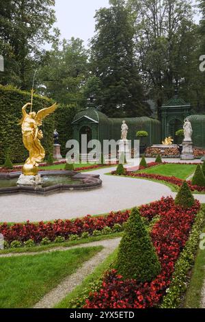 Parterre avec Bégonias rouges, topiaire dans les bordures et sculptures bordées de haies d'arbres à feuilles caduques dans le jardin formel du palais Linderhof à la fin de l'été. Banque D'Images