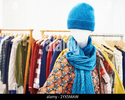 Chapeau en laine et écharpe sur le mannequin, et vêtements pour femmes dans le magasin Banque D'Images