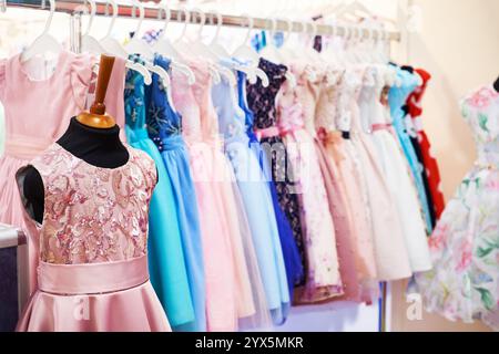 Robes élégantes pour les petites filles sur cintres dans le magasin Banque D'Images