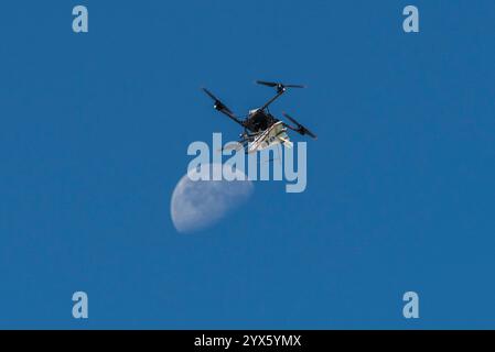 Edwards, Californie, États-Unis. 22 octobre 2024. Un modèle de sonde atmosphérique fixé à l'envers à un avion télépiloté à quad rotor monte avec la Lune visible sur Oct. 22, 2024. L'avion à quatre rotors a lancé la sonde au-dessus du lac Rogers Dry, une zone de vol adjacente au centre de recherche en vol Armstrong de la NASA à Edwards, en Californie. La sonde a été conçue et construite au centre. Steve Freeman (crédit image : © NASA/ZUMA Press Wire) USAGE ÉDITORIAL SEULEMENT! Non destiné à UN USAGE commercial ! Banque D'Images