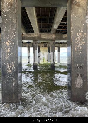 Sous la jetée : les vagues s'écrasent contre les supports en béton Banque D'Images