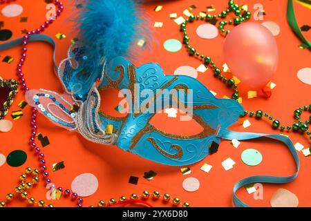 Masque de carnaval avec perles et confettis sur fond rouge Banque D'Images