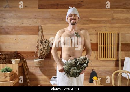 Bel homme avec fouet dans le sauna Banque D'Images