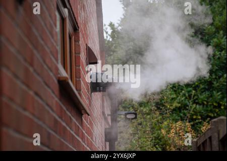 panache de vapeur sortant de l'évent d'échappement d'une chaudière de chauffage central à condensation au mazout, norfolk rural, angleterre Banque D'Images
