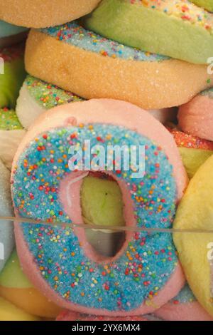 Un tableau vibrant et coloré de bonbons Donuts avec des pépines empilées haut Banque D'Images