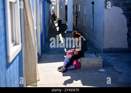 Pékin, Mexique. 11 décembre 2024. Une migrante fixe les cheveux d'une jeune fille dans un refuge de la ville frontalière de Reynosa, Tamaulipas, Mexique, 11 décembre 2024. Reynosa, une ville frontalière de Tamaulipas, se trouve de l'autre côté du Rio Grande de McAllen, Texas des États-Unis. En raison de sa situation géographique, Reynosa sert de porte d'entrée majeure pour les migrants d'Amérique centrale et d'autres régions qui tentent d'entrer aux États-Unis. Les refuges de cette région fournissent un logement temporaire aux migrants en attente de demandes d'asile, de permis de transit ou de retour dans leur foyer. Crédit : Li Muzi/Xinhua/Alamy Live News Banque D'Images