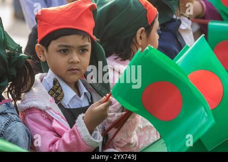 Dhaka, Bangladesh. 14 décembre 2024. Les enfants tiennent des drapeaux du Bangladesh pendant la Journée commémorative des intellectuels martyrs. Le jour commémoratif des intellectuels martyrs, le Bangladesh commémore de nombreux intellectuels bengalis qui ont tragiquement perdu la vie pendant la guerre de libération du Bangladesh en 1971. Ces intellectuels ont été délibérément ciblés et brutalement tués dans l'ex-Pakistan oriental par l'armée pakistanaise et leurs alliés, pour saper la nation émergente en éradiquant ses individus talentueux et intellectuels. Crédit : SOPA images Limited/Alamy Live News Banque D'Images