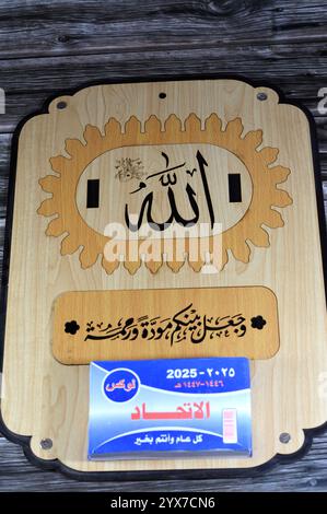 Le Caire, Egypte, 11 décembre 2024 : calendrier suspendu quotidien en bois avec bloc grégorien et hijri en langue arabe de l'année 2025, avec le nom de Dieu tout Banque D'Images