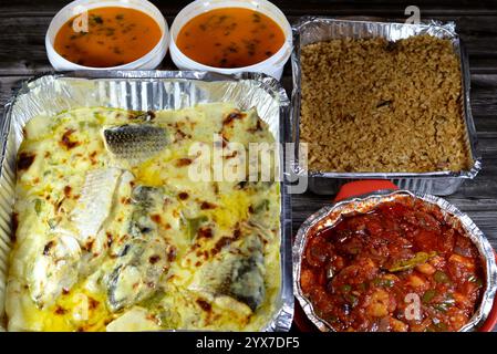Repas de fruits de mer de poissons de mulet cuits au four avec sauce blanche crémeuse, morceaux de pommes de terre, riz de poisson rouge, crevettes cuites au four avec sauce rouge et fruits de mer c Banque D'Images