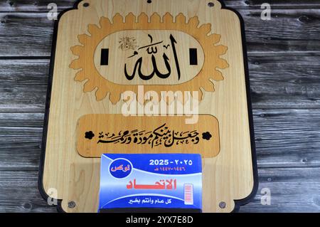 Le Caire, Egypte, 11 décembre 2024 : calendrier suspendu quotidien en bois avec bloc grégorien et hijri en langue arabe de l'année 2025, avec le nom de Dieu tout Banque D'Images