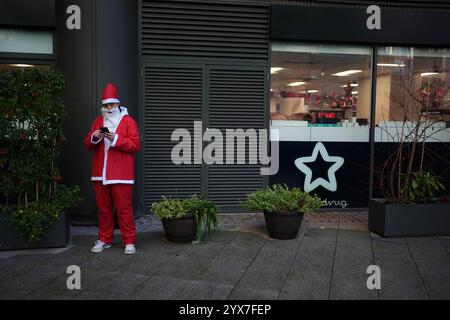 Une personne habillée en Père Noël avant de participer au défilé de Noël Santacon de Londres au Floating Pocket Park à Londres. Date de la photo : samedi 14 décembre 2024. Banque D'Images