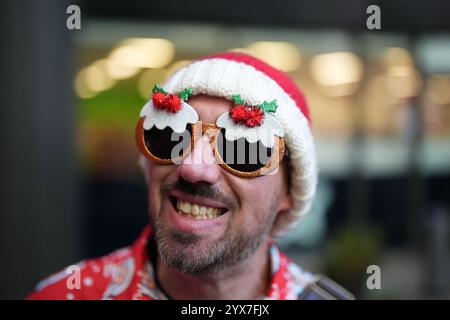 Une personne habillée en Père Noël avant de participer au défilé de Noël Santacon de Londres au Floating Pocket Park à Londres. Date de la photo : samedi 14 décembre 2024. Banque D'Images