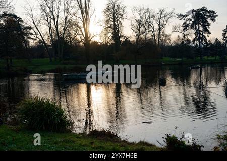 Profitez d'une promenade paisible en bateau au coucher du soleil dans le bois de Vincennes, le plus grand parc de Paris, entouré d'une nature sereine et de douces ondulations de l'eau Banque D'Images