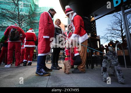 Les gens se sont habillés en Père Noël avant de participer au défilé de Noël Santacon de Londres au Floating Pocket Park à Londres. Date de la photo : samedi 14 décembre 2024. Banque D'Images