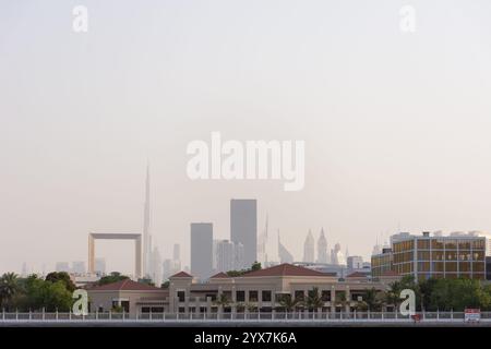 Vue brumeuse sur le Burj Khalifa et le Dubai Frame à travers Dubai Creek depuis Bur Dubai, Émirats arabes Unis. Banque D'Images