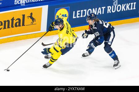 Fribourg, Suisse, 14 décembre 2024 : #44 Victor Ejdsell (Suède) couvre la rondelle contre #50 Juuso Riikola (Finlande). (Photo de Andreas Haas/dieBildmanufaktur) crédit : dieBildmanufaktur/Alamy Live News Banque D'Images