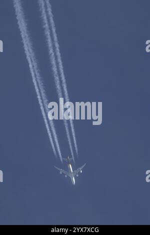 Boeing 747 jumbo jet cargo avion d'UPS volant dans un ciel bleu avec une traînée de vapeur ou traînée derrière, Angleterre, Royaume-Uni, Europe Banque D'Images