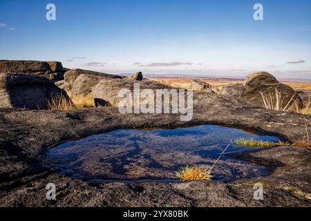 Petit bassin d'eau dans une dépression des pierres de grincement de Blackstone Edge, Rochdale, Angleterre. Banque D'Images