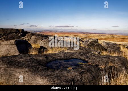 Petit bassin d'eau dans une dépression des pierres de grincement de Blackstone Edge, Rochdale, Angleterre. Banque D'Images