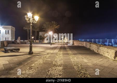 Lampadaires dans la vieille ville Alghero front de mer la nuit. Sardaigne, Italie Banque D'Images