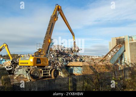 Chargeuse mécanique avec un bras de grappin dans une installation de recyclage de métaux sur le quai à Inverkeithing, Fife, Écosse Banque D'Images