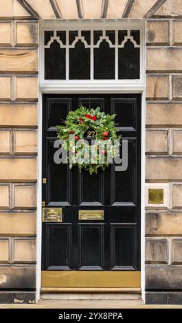 Panneau avant géorgien peint porte noire avec lumière de ventilateur et couronne de Noël, Edinburgh New Town, Écosse, Royaume-Uni Banque D'Images